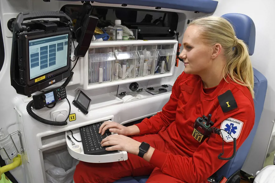 En person i rød frakk ved hjelp av en datamaskin