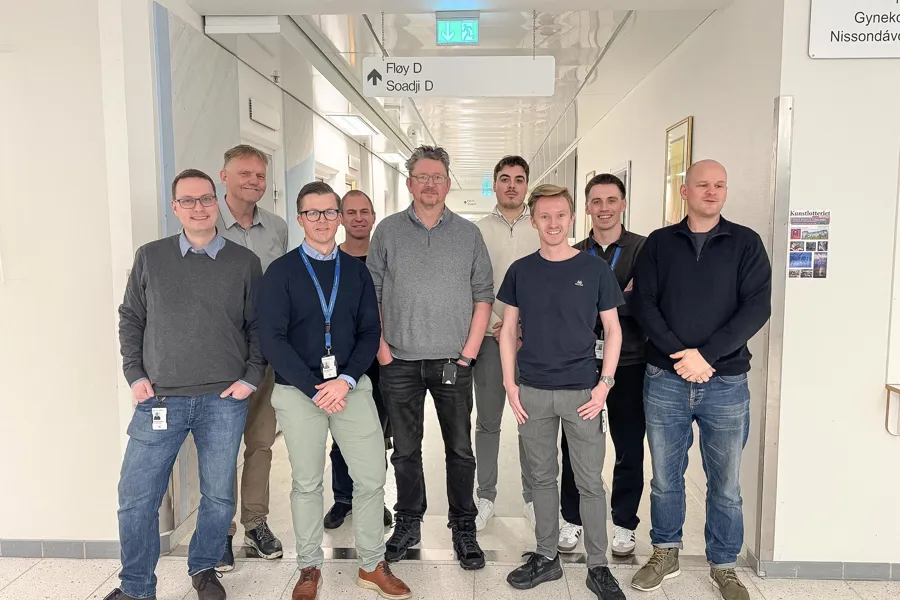 En gruppe menn, som alle er medlemmer i prosjektet SIKTH, står oppstilt i gangen på Universitetssykehuset Nord-Norge