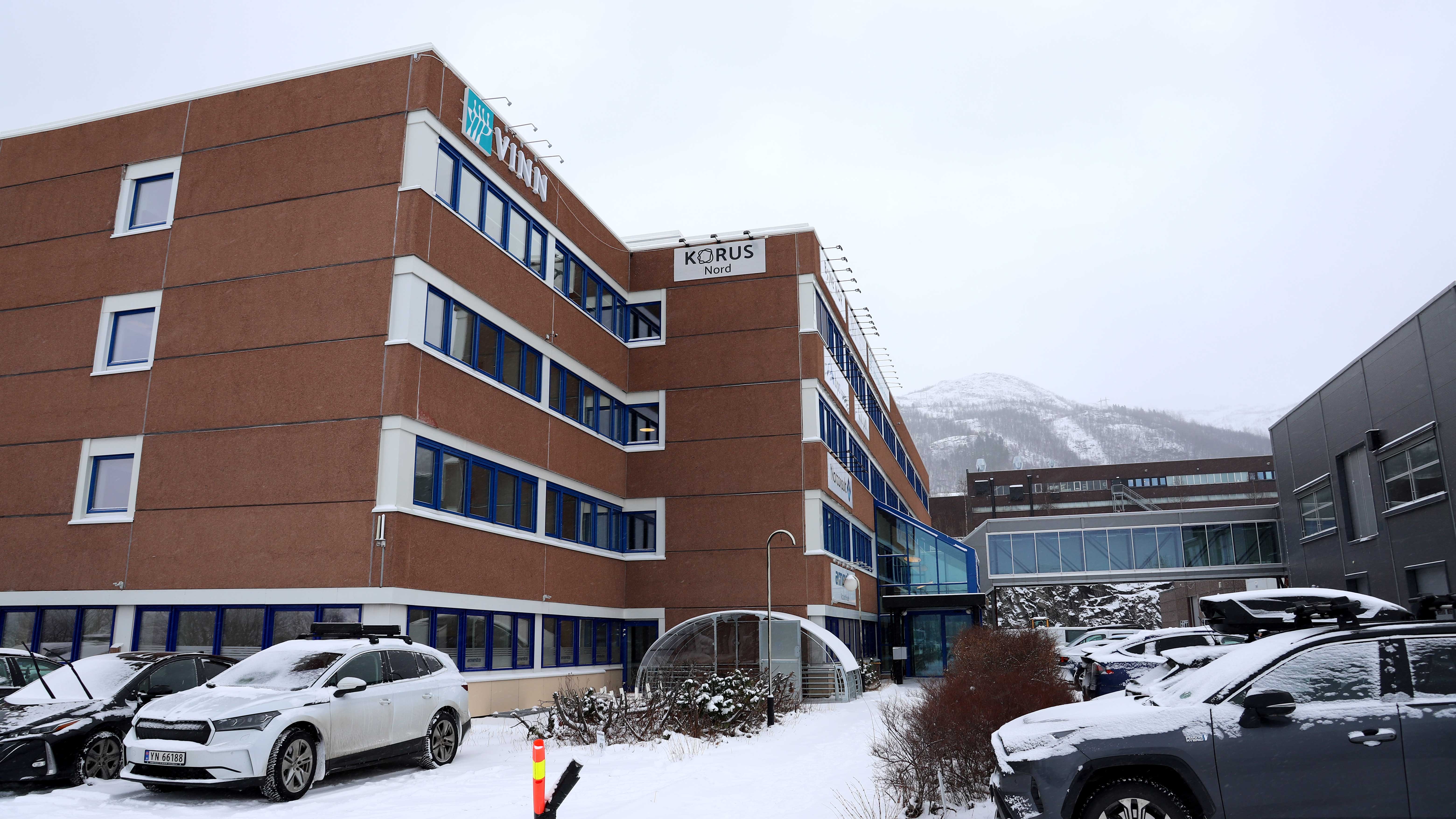 En bygning med biler parkert foran