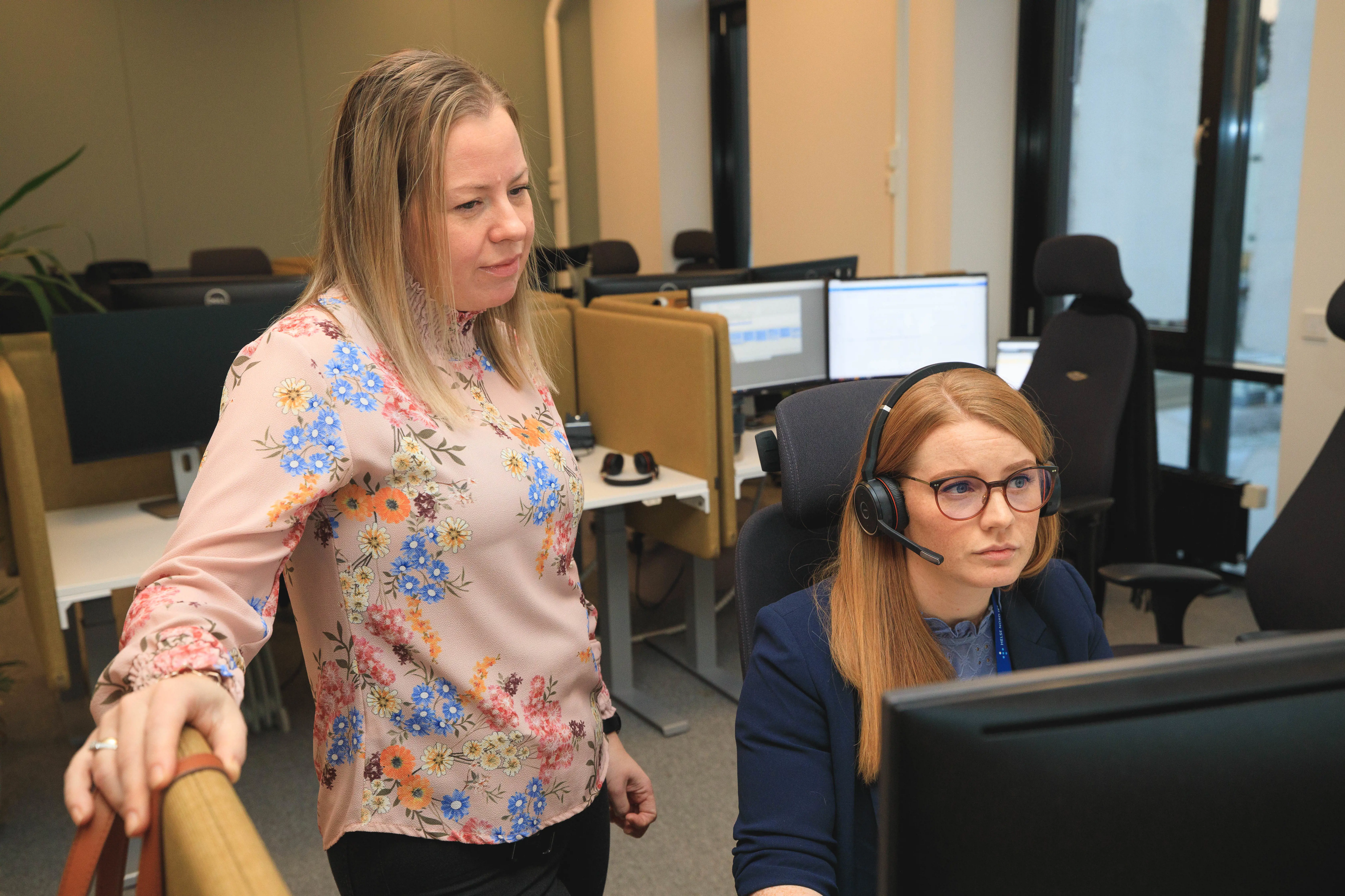 To kvinnelige ansatte ser på samme dataskjerm og konsentrerer seg om jobben. Foto