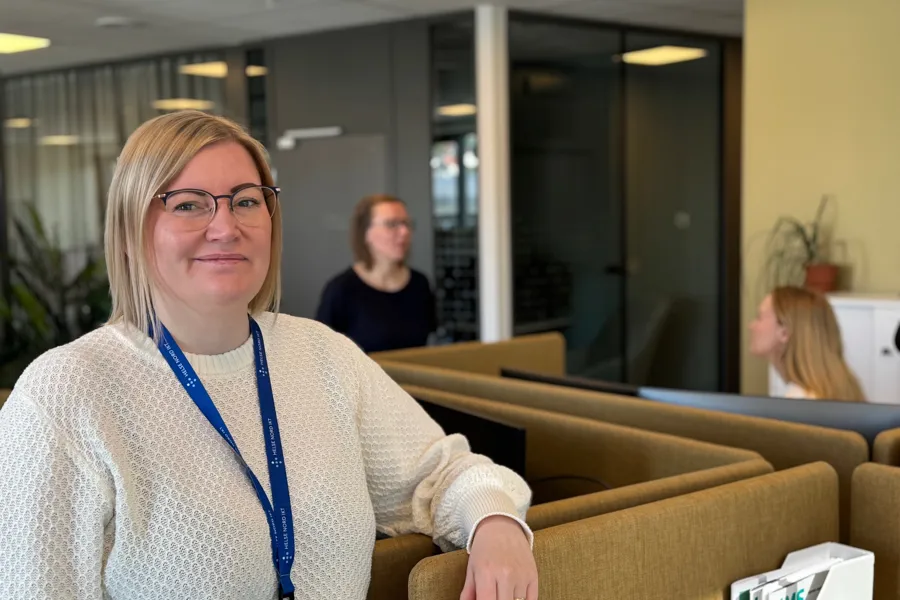 En kvinne som står i et kontorlandskap