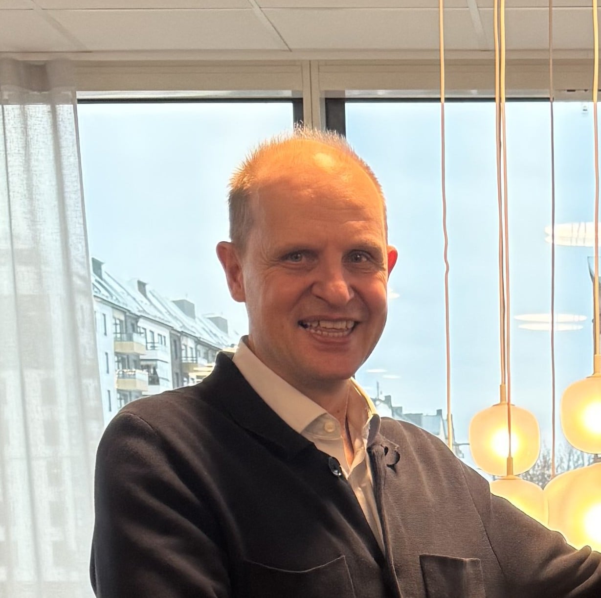 En mann som smiler til kameraet