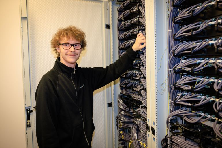 En mann som holderi et serverrack.